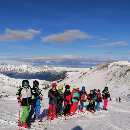 Schifahrer:innen mit traumhaftem Bergpanorama im Hintergrund
